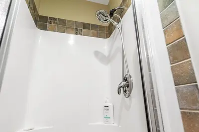 a shower in a bathroom with a shower head at Blue Mountain Getaway Located on Golf Course in Blue Mountains