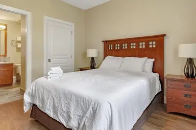 a bedroom with a large white bed and a bathroom at Blue Mountain Getaway Located on Golf Course in Blue Mountains