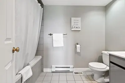 a white bathroom with a toilet and a sink at All Seasons Sierra Lane Retreat 88371 in Blue Mountains