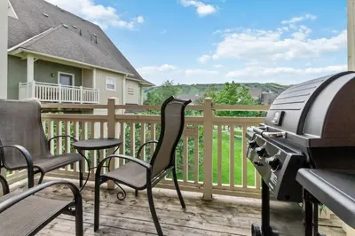 a bbq on a deck with chairs and a grill at Rivergrass Townhouse in Blue with Pool Golf Skiing - 219 Rivergrass in Blue Mountains