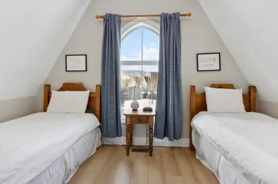 two beds in a attic room with a window at 3BR Snowbridge Chalet in Blue with Golf Course View in Collingwood