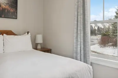 a bedroom with a white bed and a window at 3BR Snowbridge Chalet in Blue with Golf Course View in Collingwood