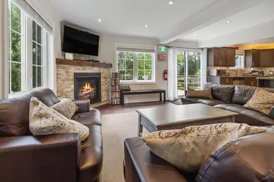 a living room with leather furniture and a fireplace at Scandia Retreat with Hot Tub, Sauna and Fire Pit in Blue Mountains