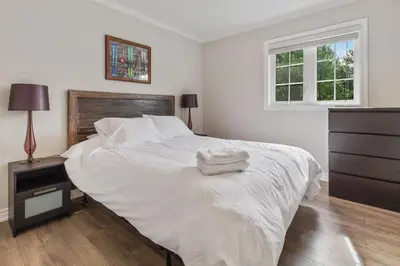 a white bed with two towels on it in a bedroom at Scandia Retreat with Hot Tub, Sauna and Fire Pit in Blue Mountains