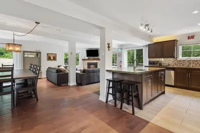 a kitchen and living room with a table and a couch at Scandia Retreat with Hot Tub, Sauna and Fire Pit in Blue Mountains