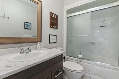 a bathroom with a sink and a toilet and a mirror at Scandia Retreat with Hot Tub, Sauna and Fire Pit in Blue Mountains