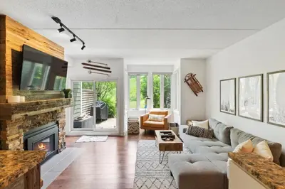 a living room with a couch and a fireplace at Modern Mountainside Ski in Ski out 87111 in Blue Mountains