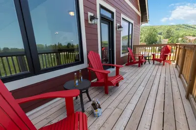 a deck with red chairs and a table and windows at Luxurious Arlberg Retreat 89883 in Blue Mountains