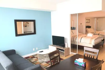 a living room with a couch and a bedroom at Magnificient View next CN Tower/Rogers/Union/MTCC in Toronto