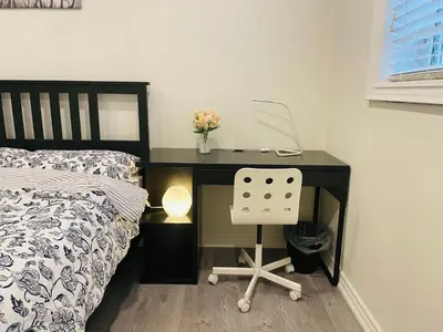 a desk with a computer on it next to a bed at MT house in Mississauga