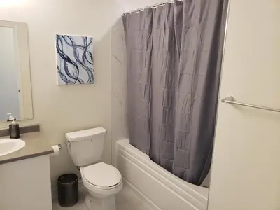 a bathroom with a toilet and a shower curtain at Luxurious Condo Apartment 2BRs-1BAs-1Office with free parking in Brampton