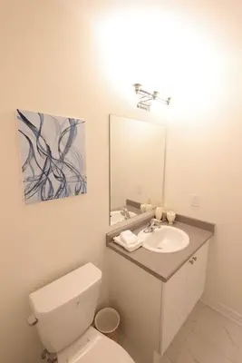 a bathroom with a white toilet and a sink at Luxurious Condo Apartment 2BRs-1BAs-1Office with free parking in Brampton