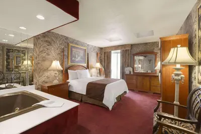 a hotel room with a bed and a bath tub at Travelodge by Wyndham Niagara Falls Fallsview in Niagara Falls
