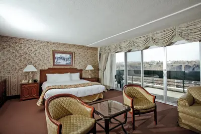 a hotel room with a bed and a table and chairs at Travelodge by Wyndham Niagara Falls Fallsview in Niagara Falls