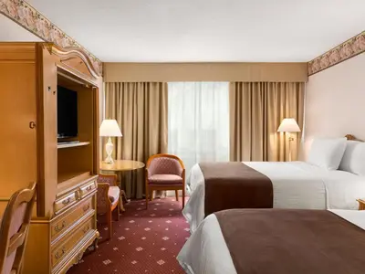 a hotel room with two beds and a television at Travelodge by Wyndham Niagara Falls Fallsview in Niagara Falls