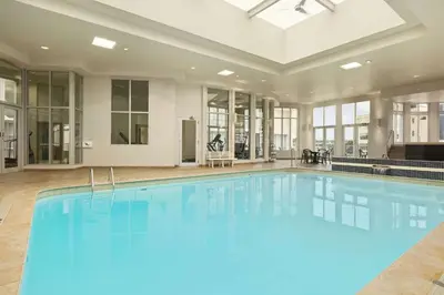 a large swimming pool with blue water in a building at Travelodge by Wyndham Niagara Falls Fallsview in Niagara Falls