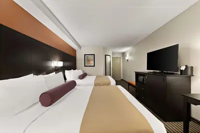 a hotel room with two beds and a flat screen tv at Best Western Plus Toronto North York Hotel & Suites in Toronto