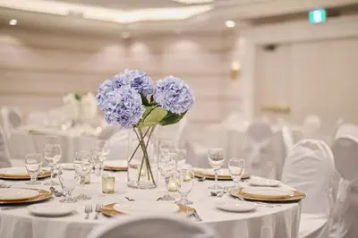 a table with a vase of purple flowers on it at Holiday Inn Hotel & Suites St.Catharines-Niagara by IHG in St. Catharines