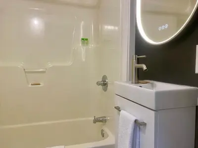 a bathroom with a sink and a tub and a toilet at Ranch House Inn in Exeter