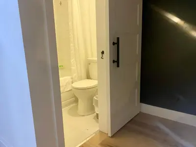 a bathroom with a toilet and a door open at Ranch House Inn in Exeter