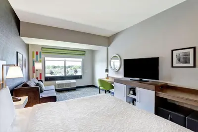 a hotel room with a bed and a flat screen tv at Hampton Inn St. Catharines Niagara in St. Catharines