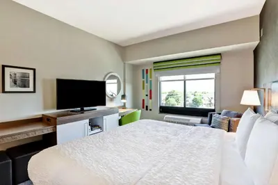 a hotel room with a bed and a flat screen tv at Hampton Inn St. Catharines Niagara in St. Catharines