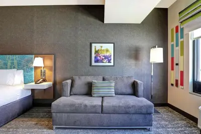 a hotel room with a couch and a bed at Hampton Inn St. Catharines Niagara in St. Catharines
