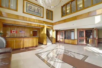 a lobby of a building with a chandelier at Woodbine Hotel & Suites in Toronto