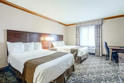 a hotel room with two beds and a desk at Woodbine Hotel & Suites in Toronto