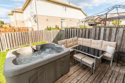 a hot tub on a deck with a table and chairs at GlobalStay 3 Bedroom Townhome with Hot Tub Hamilton in Hamilton