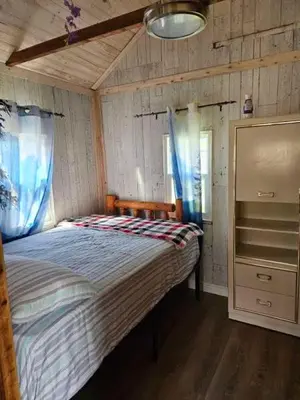 a bedroom with a large bed in a room at Fun Place with a Sandy Beach for Swimming, Boating & Fishing, Featuring 1 House and 3 Cabins in Fenelon Falls