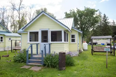 a small yellow house with a gazebo at Fun Place with a Sandy Beach for Swimming, Boating & Fishing, Featuring 1 House and 3 Cabins in Fenelon Falls