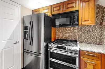 a kitchen with a stainless steel refrigerator and microwave at Wintergreen 119 in Blue Mountains