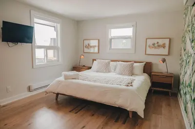 a bedroom with a large bed and two windows at Penny's Motel in Thornbury