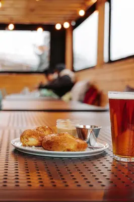 a plate of food on a table with a glass of beer at Penny's Motel in Thornbury