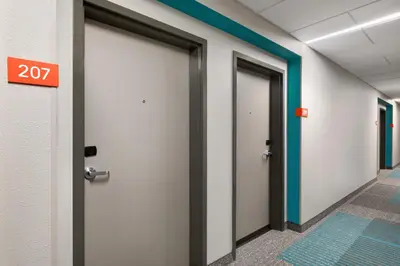 a row of doors in a hallway with a exit sign at avid Hotel - Toronto - Vaughan Southwest by IHG in Vaughan