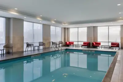 a swimming pool in a hotel with chairs and tables at avid Hotel - Toronto - Vaughan Southwest by IHG in Vaughan
