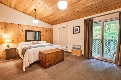 a bedroom with a bed and a large window at 3 Pines Lodge Muskoka in Huntsville
