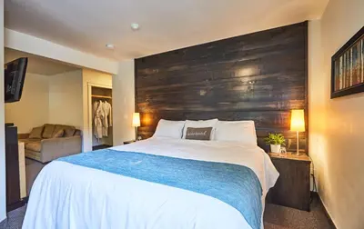 a bedroom with a large bed with a wooden headboard at 3 Pines Lodge Muskoka in Huntsville