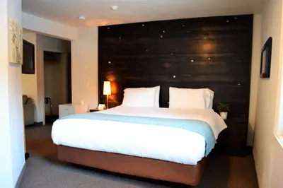 a bedroom with a large bed with a large wooden headboard at 3 Pines Lodge Muskoka in Huntsville