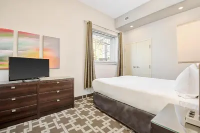 a bedroom with a large bed and a flat screen tv at Willowdale Hotel Toronto North York in Toronto