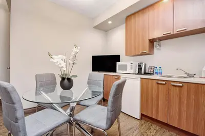 a kitchen with a glass table and chairs and a microwave at Willowdale Hotel Toronto North York in Toronto