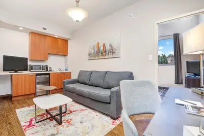 a living room with a couch and a kitchen at Willowdale Hotel Toronto North York in Toronto