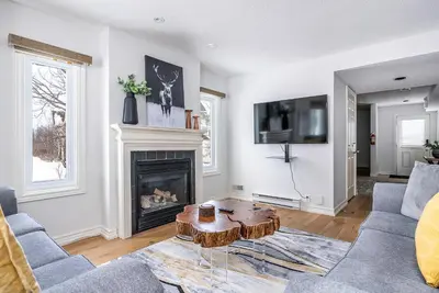 a living room with a table and a fireplace at Luxurious Blue Mountain 3BR & 3BTH Walk-in to Village in Blue Mountains