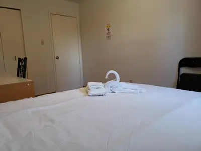 a white bed with two folded towels on it at Private Rooms in House in North York Shared Kitchen in Toronto