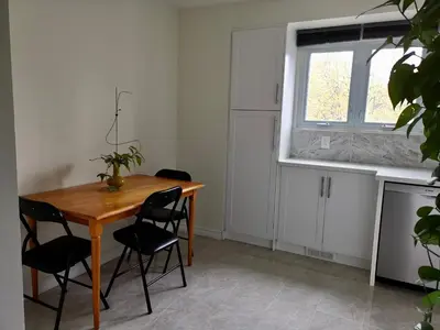 a kitchen with a wooden table and chairs and a window at Private Rooms in House in North York Shared Kitchen in Toronto