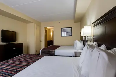 a hotel room with two beds and a flat screen tv at Country Inn & Suites by Radisson, Niagara Falls, ON in Niagara Falls