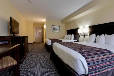 a hotel room with two beds and a flat screen tv at Country Inn & Suites by Radisson, Niagara Falls, ON in Niagara Falls