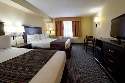 a hotel room with two beds and a flat screen tv at Country Inn & Suites by Radisson, Niagara Falls, ON in Niagara Falls