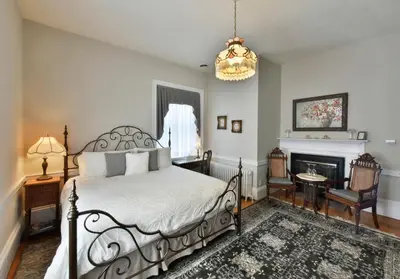 a bedroom with a bed and a fireplace at Brockamour Manor Bed and Breakfast in Niagara on the Lake